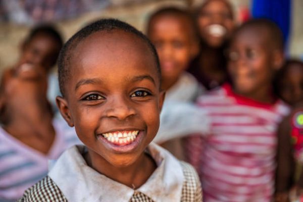 Group of colorful dressed, happy African children, orphanage in Kenya. There is no light and electricity inside the classroom. Around 20-30 orphans live in this orphanage which is located near Nairobi.